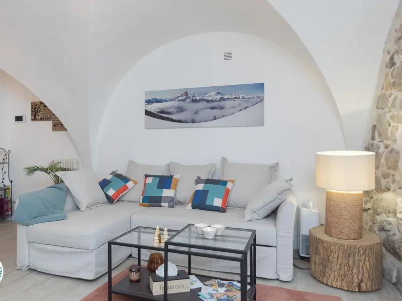 Le canapé d'angle du salon voûté, sous la toile panoramique du Mont Aiguille